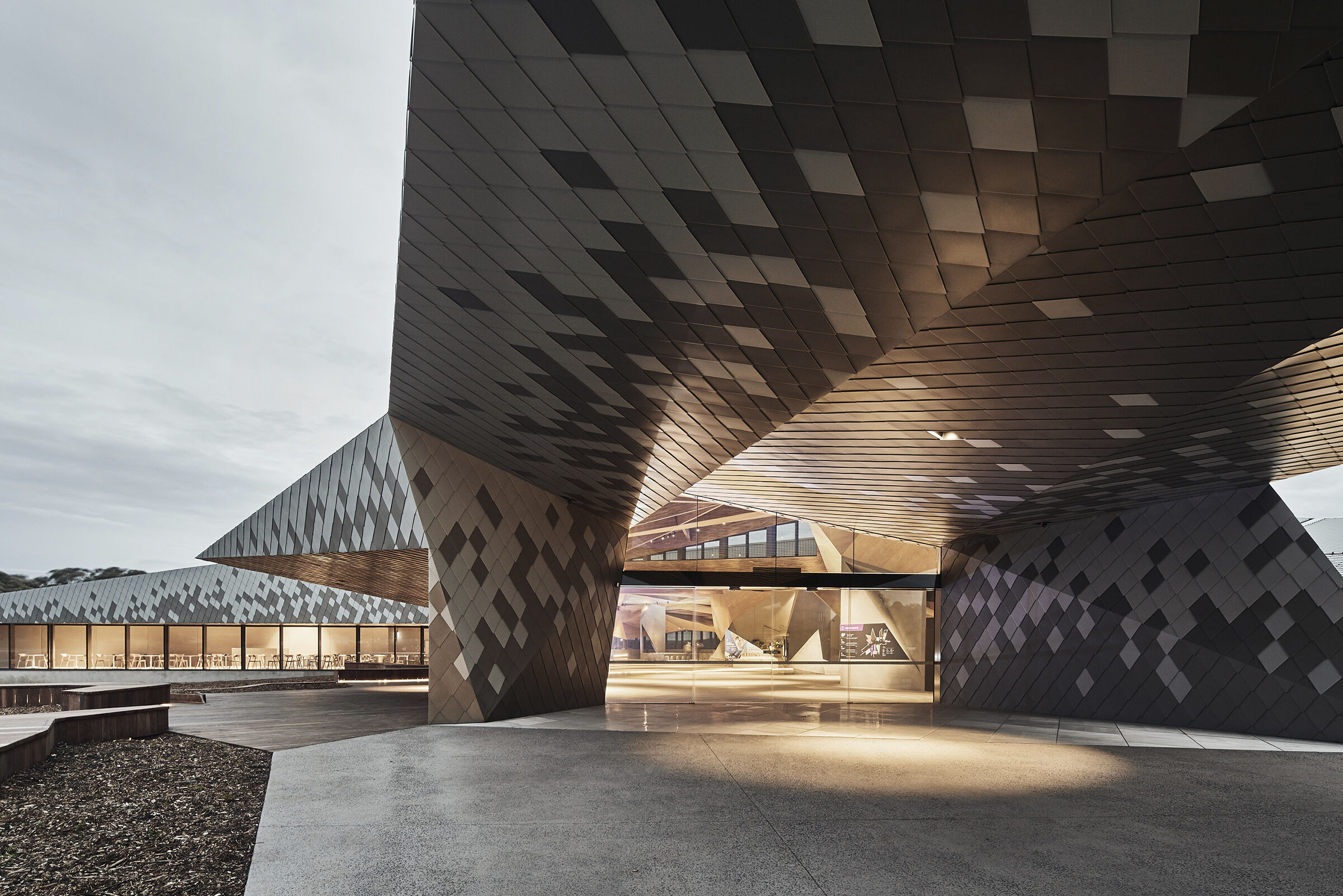 elZinc Canada — Alkimi diamond-pattern zinc shingle cladding on faceted entrance canopy, supplied by Exterior Technologies Group