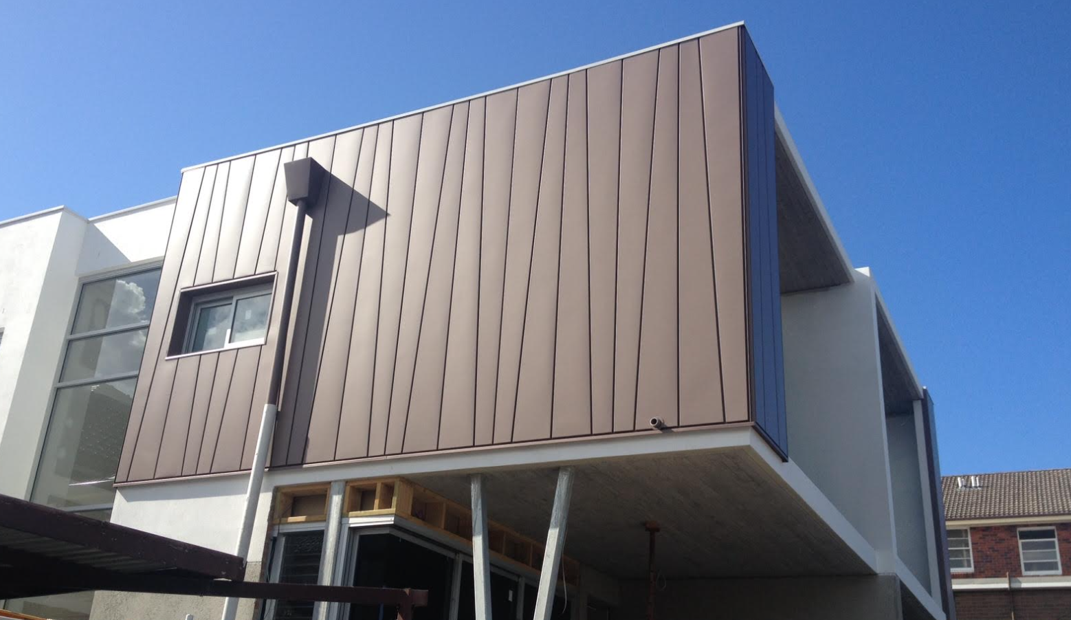 elZinc Canada — Rainbow Copper standing-seam cladding on cantilevered residential volume, supplied by Exterior Technologies Group